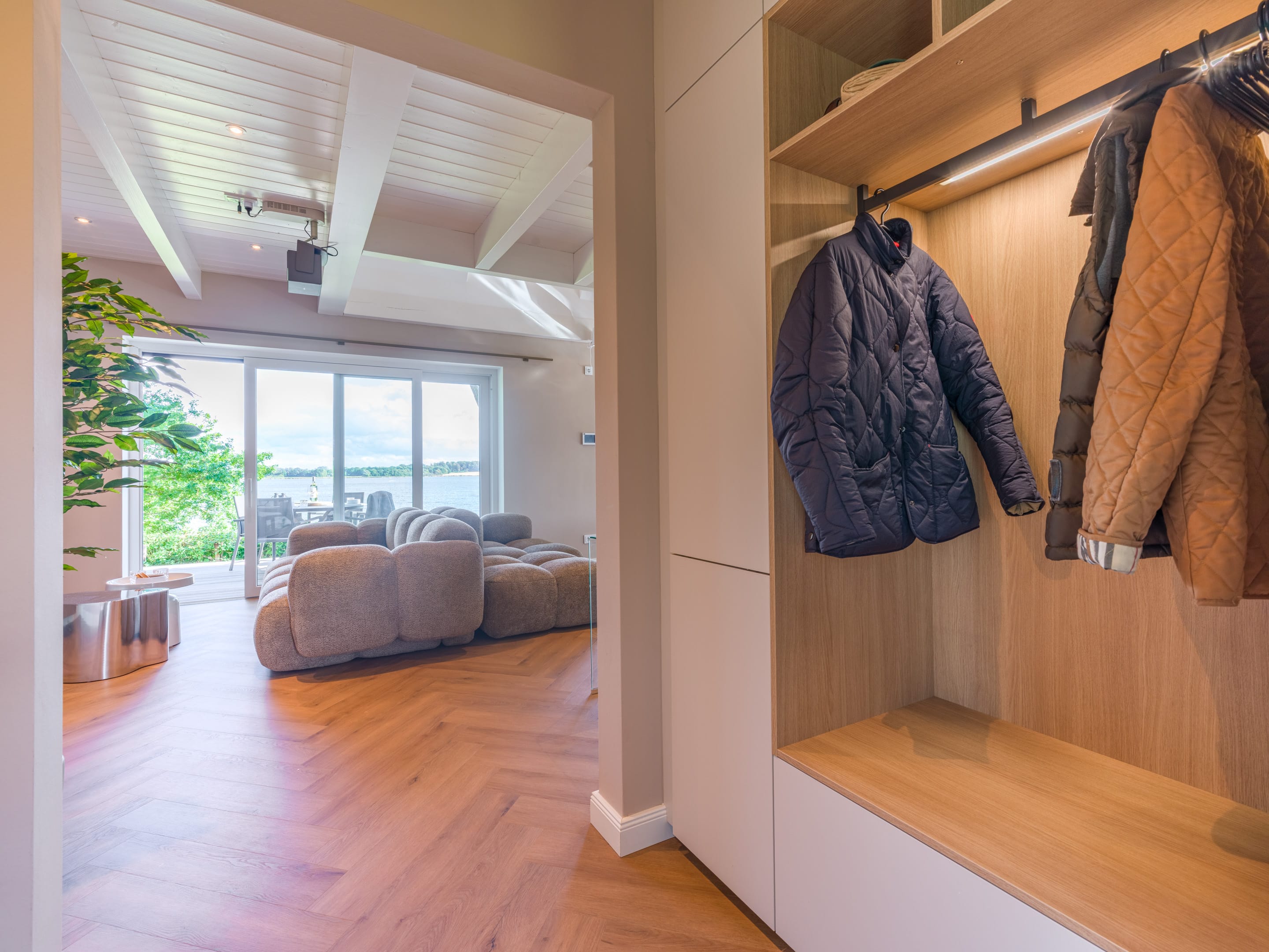 Garderobe mit Einbaumöbeln am Eingang mit Blick ins Wohnzimmer