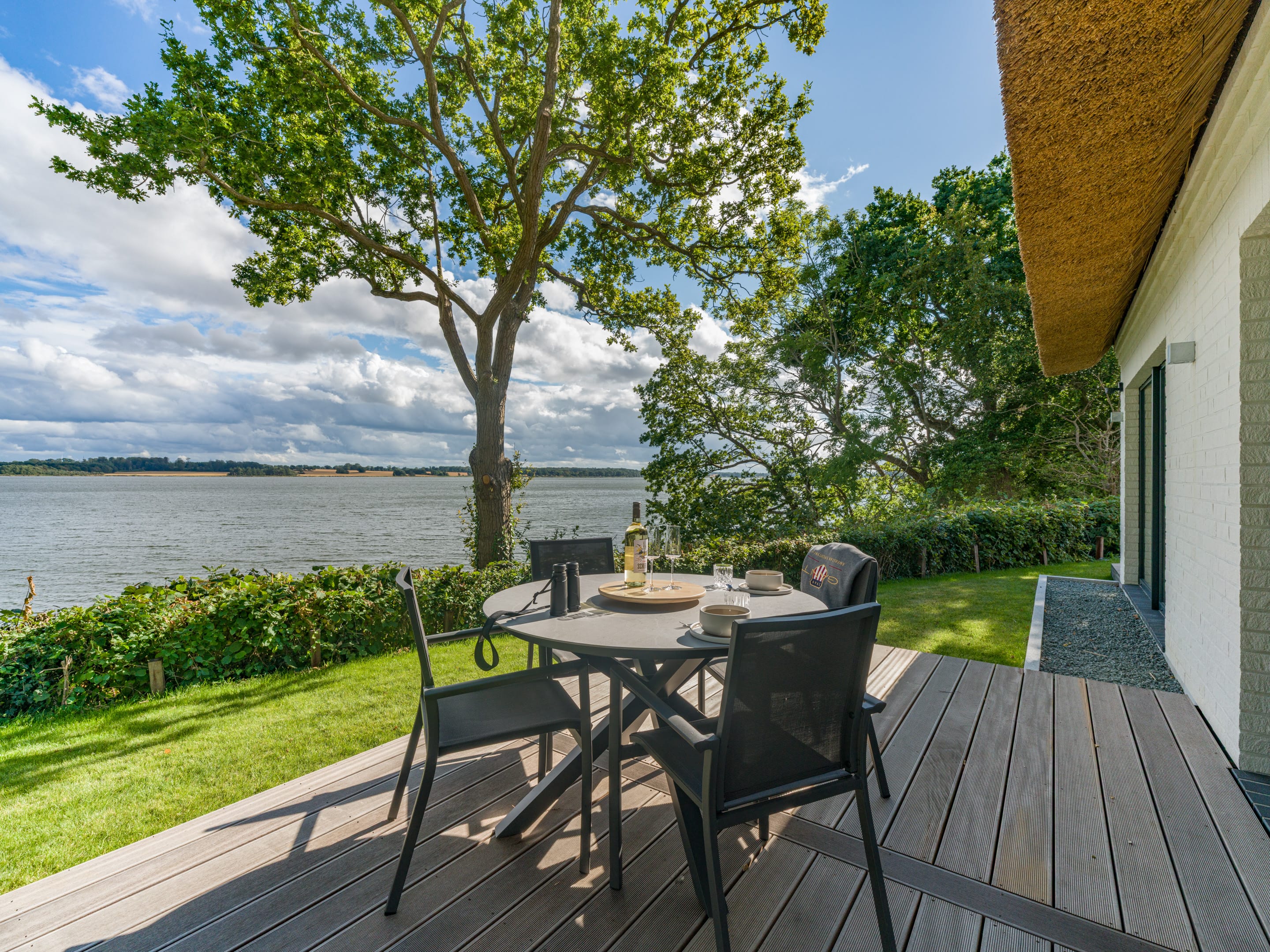 Gedeckter Esstisch auf der Terrasse mit Blick über die Schlei