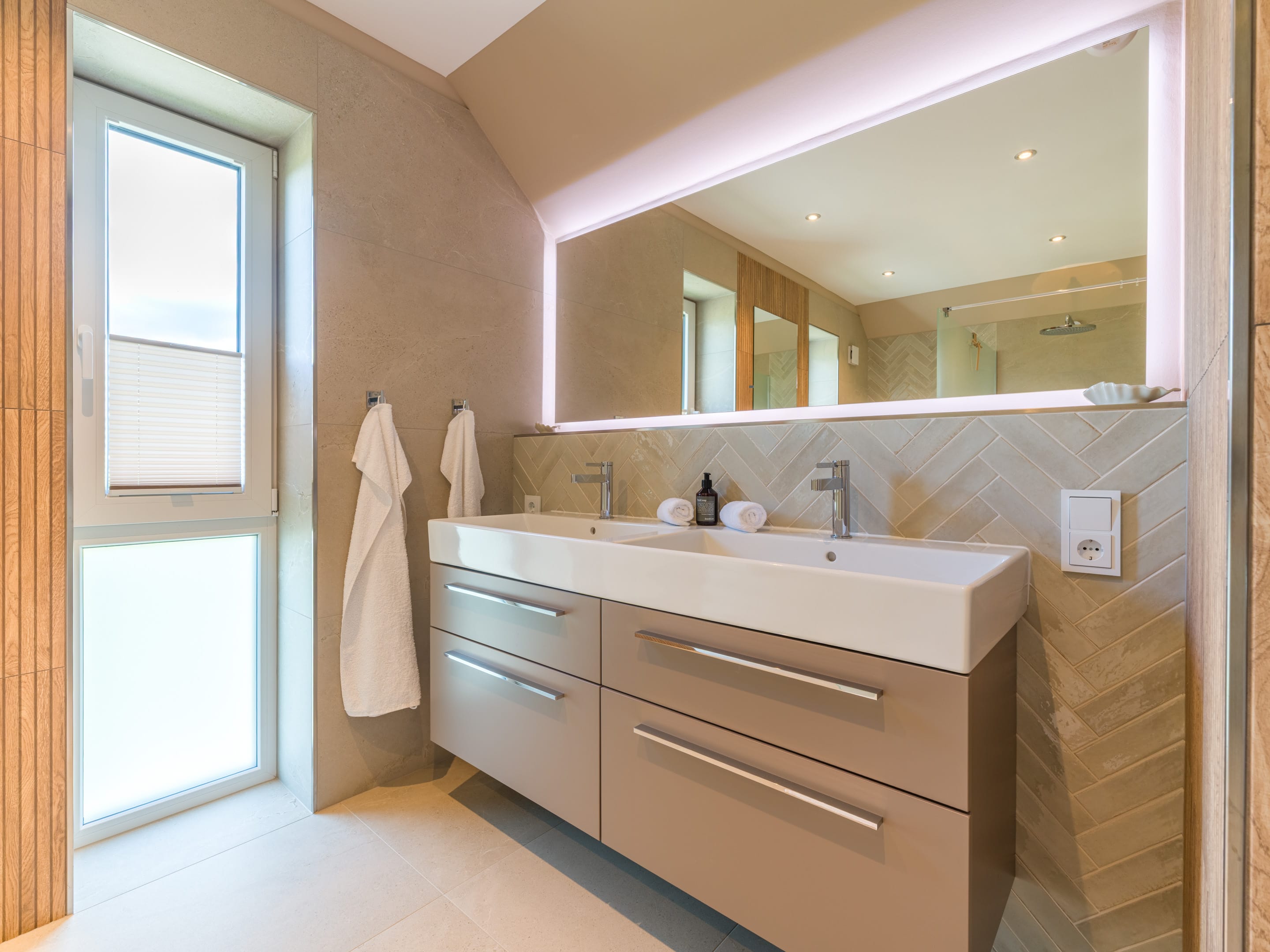 Main bathroom with double vanity and herringbone wall tiles