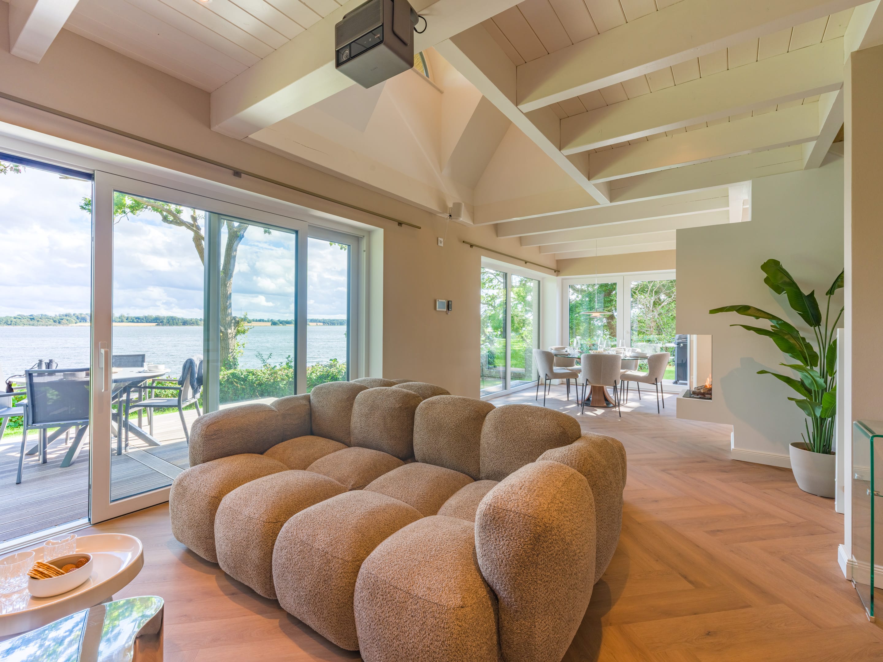 Living room with herringbone floor and sliding door to the large terrace
